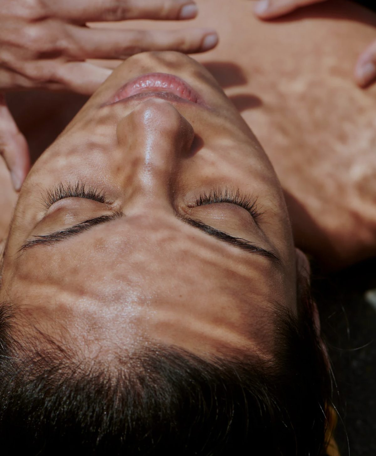 Close-up of a client receiving treatment, skin in dappled light